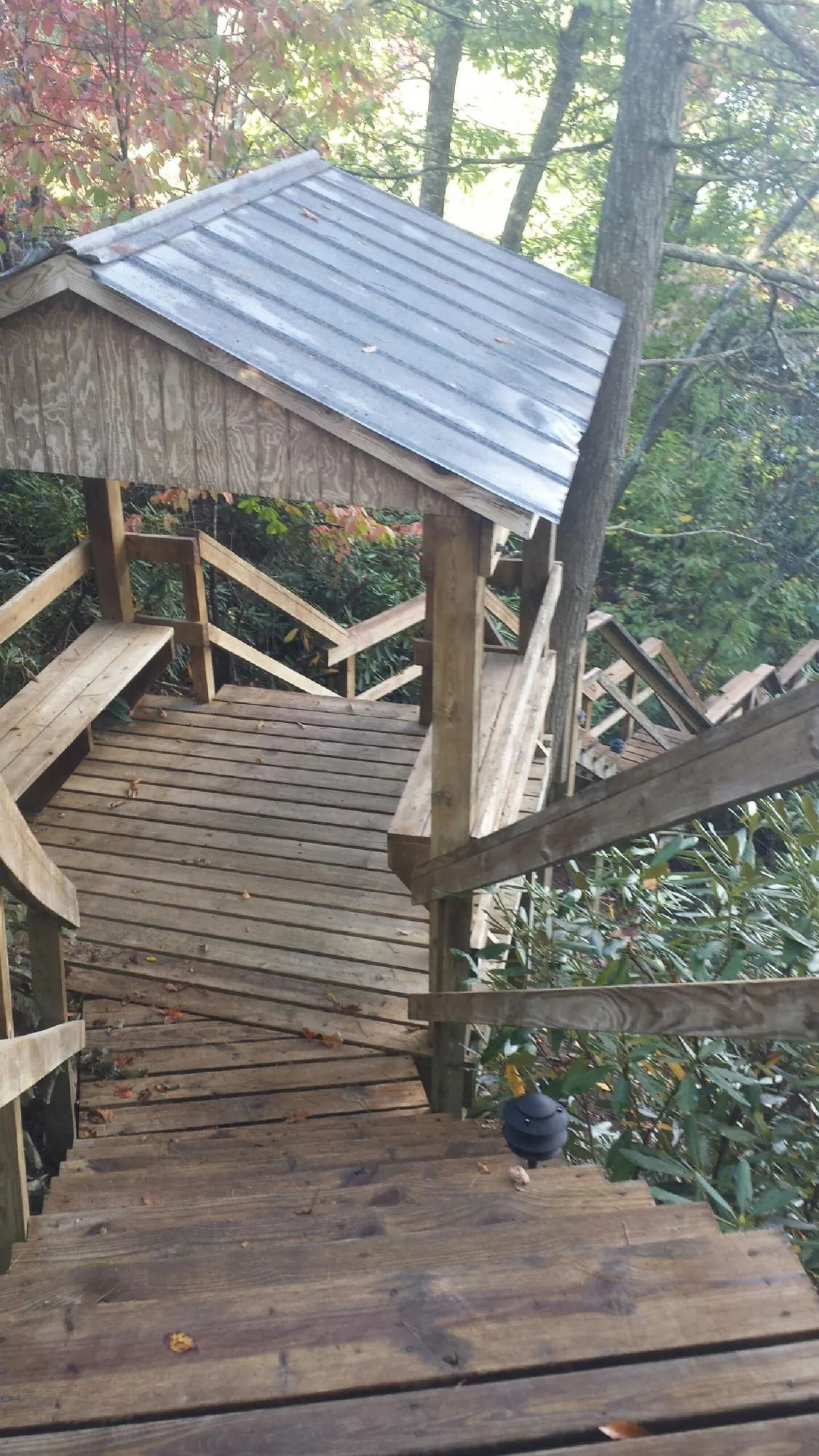 Metal roofed shelter over wooden steps on a wooded walkway — Skylight Repair & Installation work by our crew in Fillmore